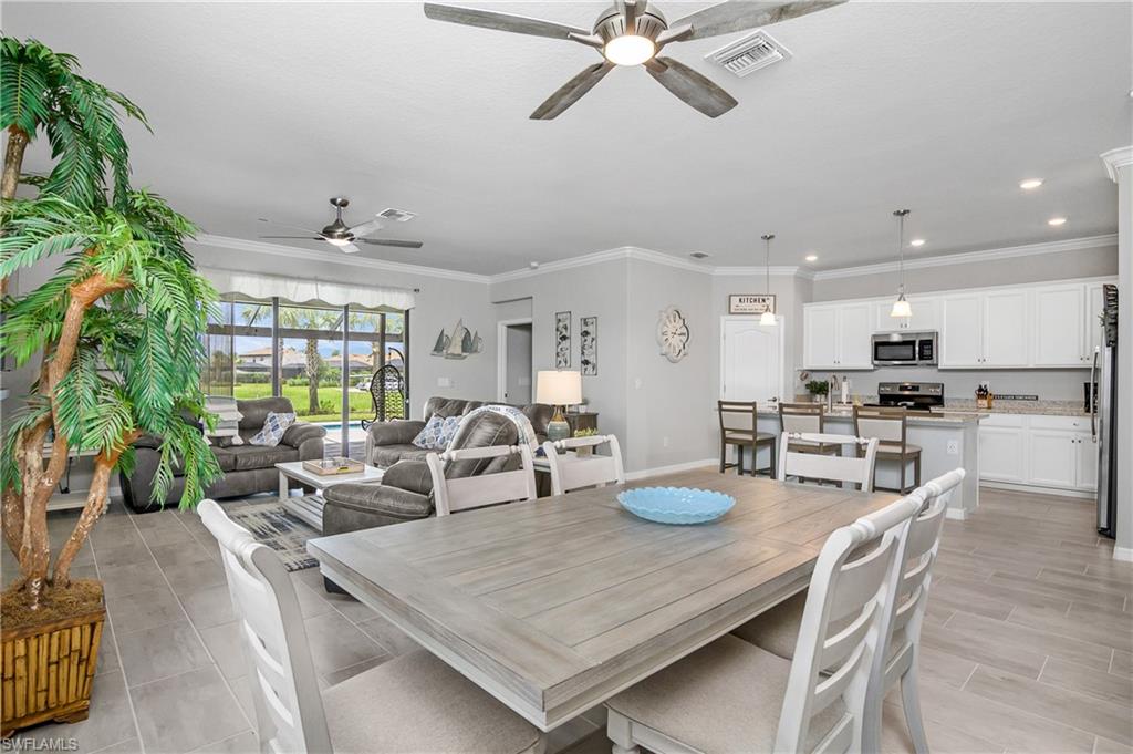 19828 The Pl Boulevard Estero, FL 33928 - Photo 2 of 37 a dinning room with stainless steel appliances kitchen island granite countertop furniture and a kitchen view