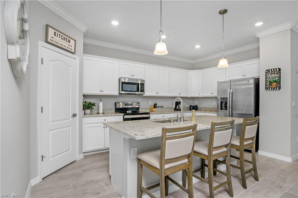 19828 The Pl Boulevard Estero, FL 33928 - Photo 4 of 37 a kitchen with stainless steel appliances a stove refrigerator sink and microwave