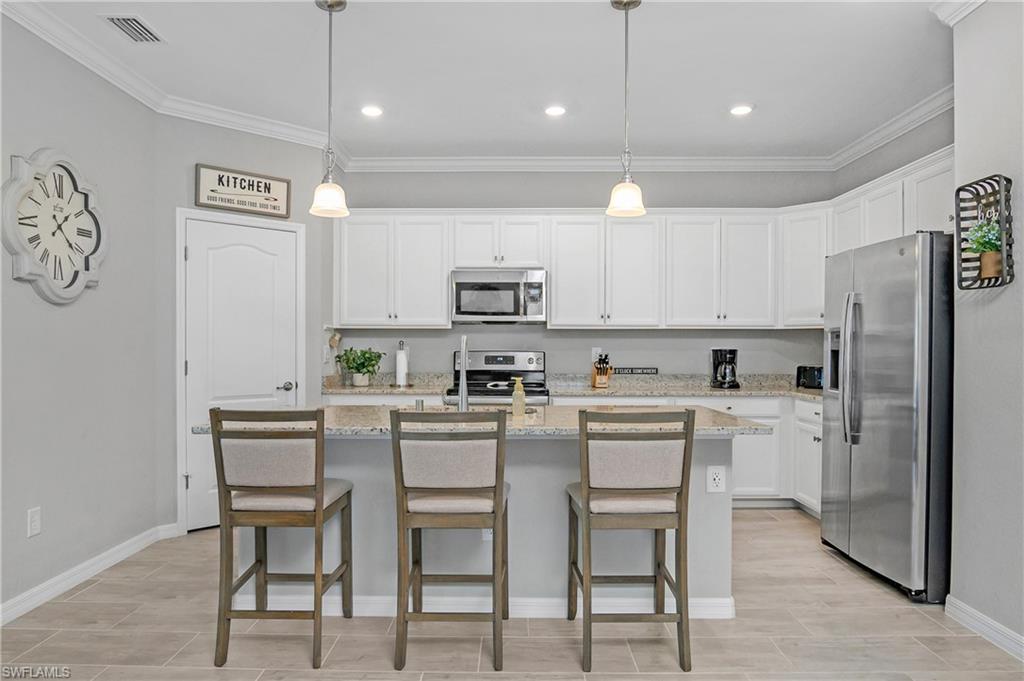 19828 The Pl Boulevard Estero, FL 33928 - Photo 5 of 37 a kitchen with cabinets a sink stainless steel appliances and a window