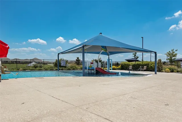 a view of patio with a table and chairs under an umbrella