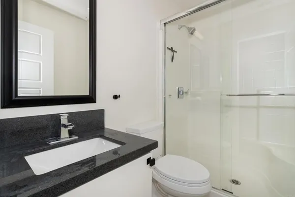 a bathroom with a sink toilet vanity and shower