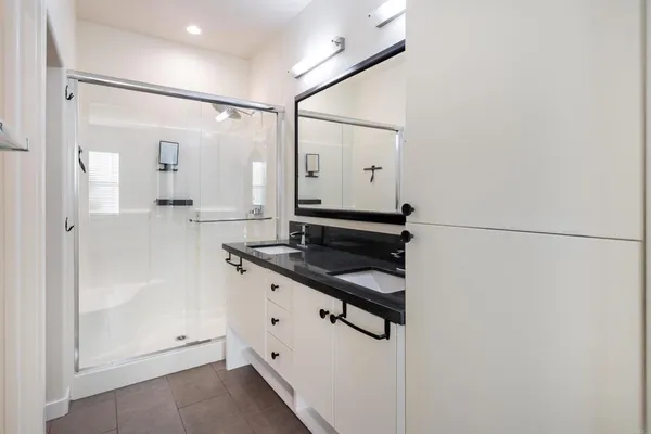 a bathroom with a sink a mirror and shower
