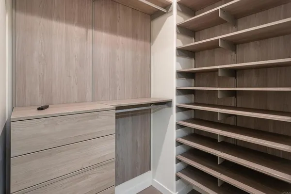 a view of walk in closet with empty racks