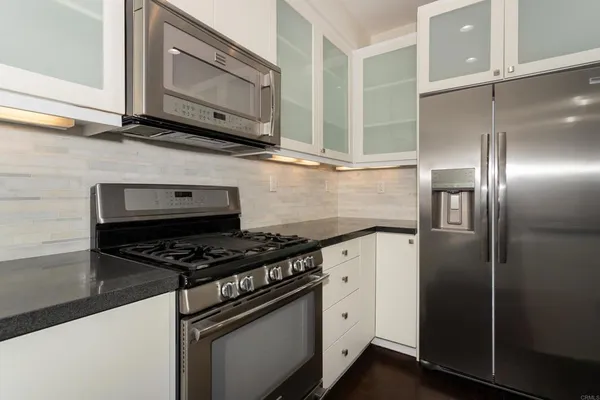 a kitchen with stainless steel appliances granite countertop a stove and a microwave