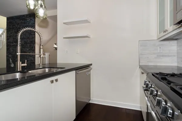 a kitchen with granite countertop a sink and a stove