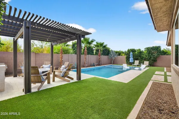 a view of a backyard with table and chairs potted plants with wooden fence