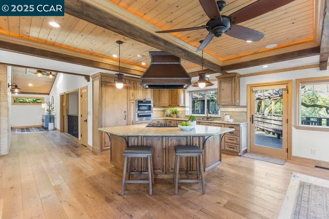 a dining hall with stainless steel appliances a dining table chairs and wooden floor