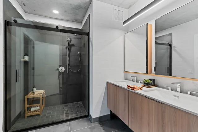 a bathroom with a granite countertop sink mirror and shower