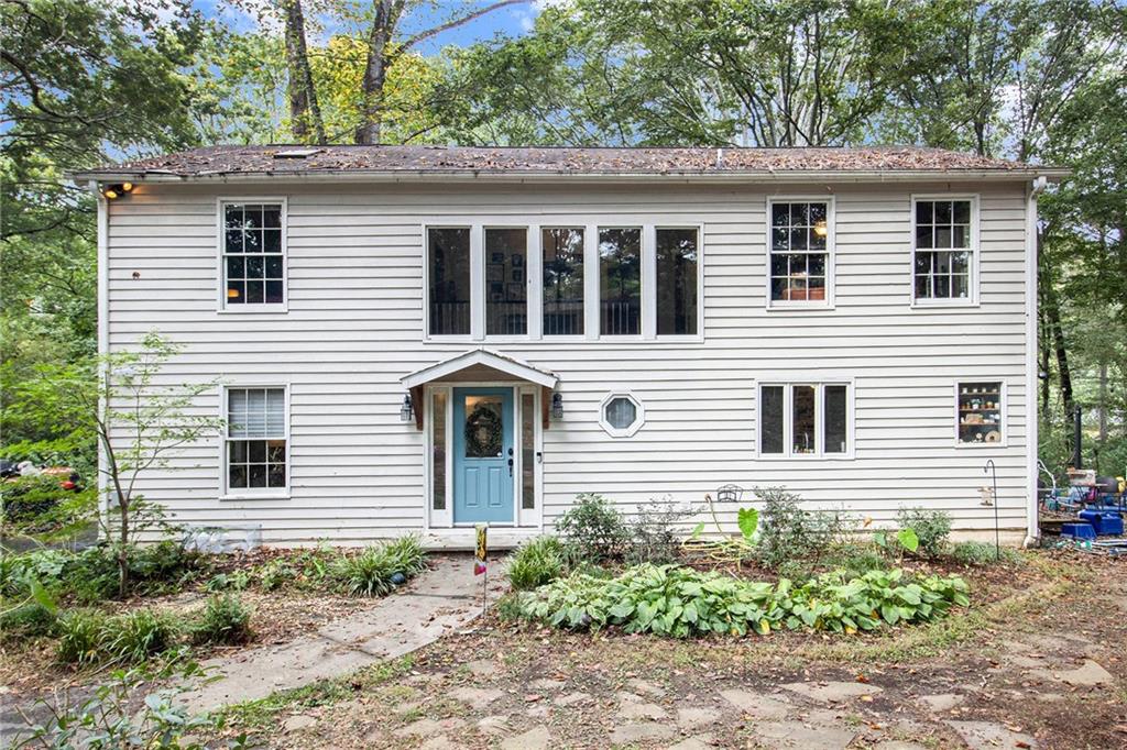 a view of a house with a yard and large tree