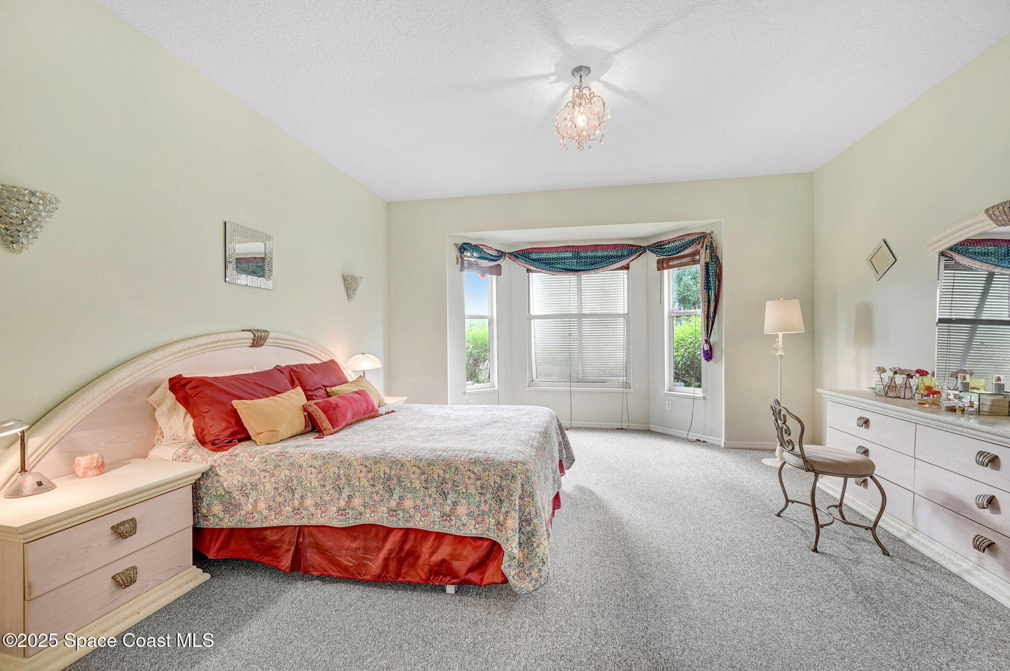 4341 Aberdeen Circle Rockledge, FL 32955 - Photo 22 of 43 a bedroom with a bed a chandelier and a dresser