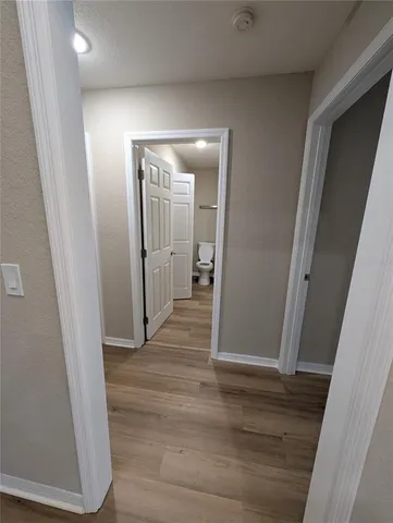 a view of a hallway with wooden floor