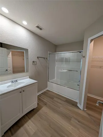 a bathroom with a granite countertop sink mirror and shower