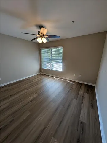 a view of wooden floor and a chandelier fan in a room