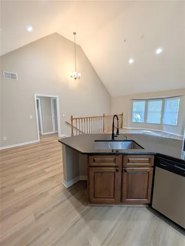 a kitchen with kitchen island a sink and wooden floor