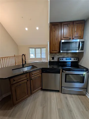 a kitchen with granite countertop stainless steel appliances and wooden cabinets