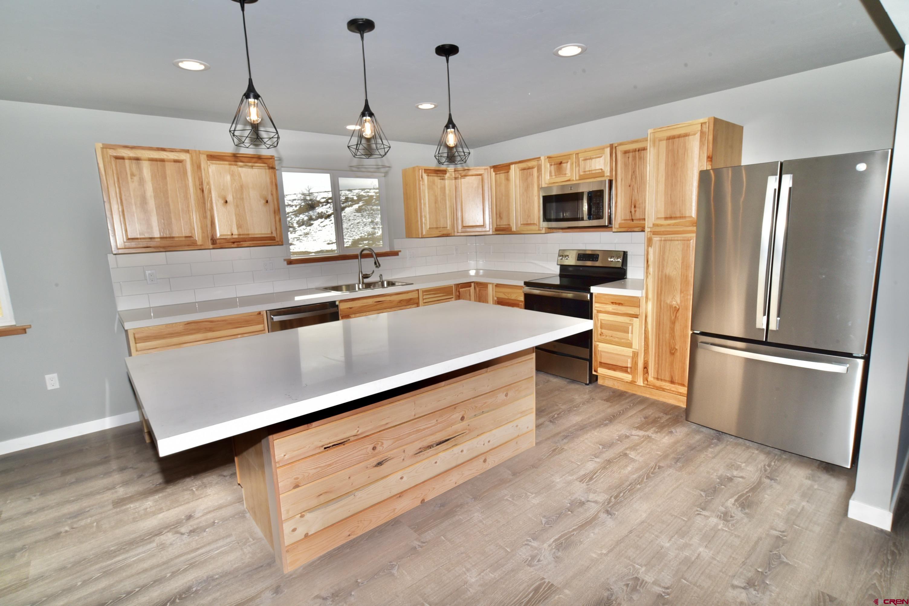 66462 Landfill Road Montrose, CO 81401 - Photo 14 of 30 a kitchen with stainless steel appliances granite countertop a refrigerator a sink and a stove