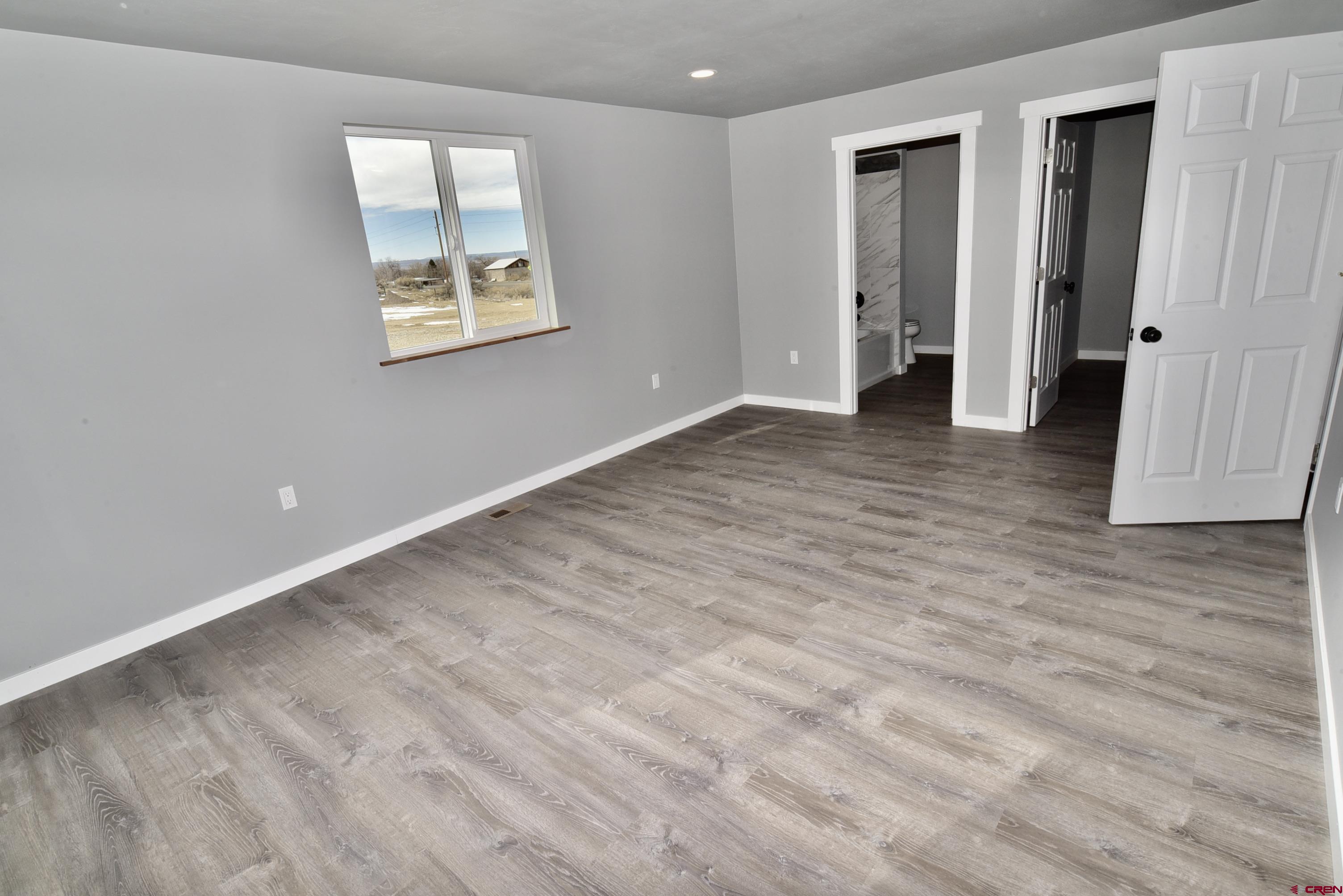 66462 Landfill Road Montrose, CO 81401 - Photo 19 of 30 a view of an empty room with wooden floor and a window