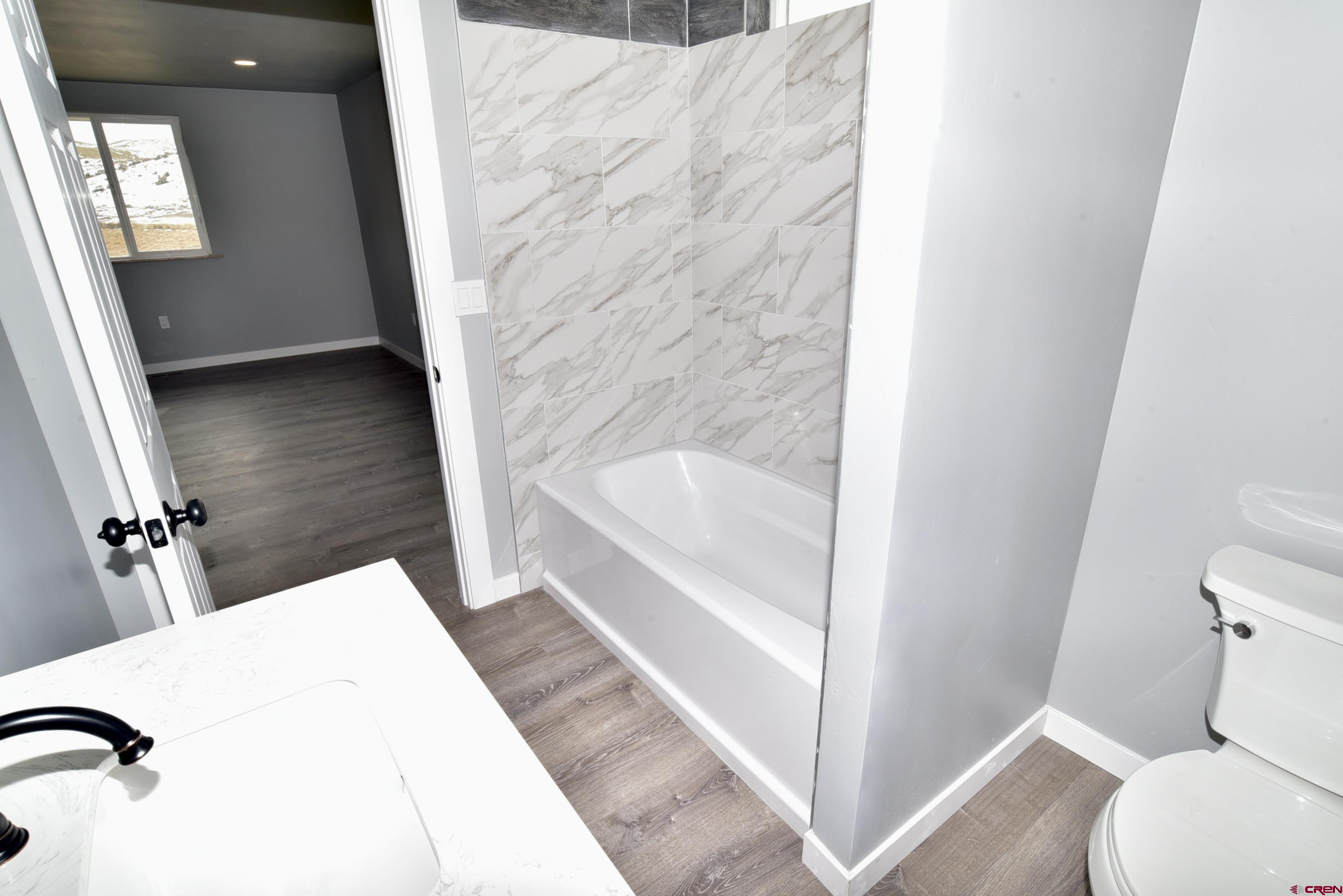 66462 Landfill Road Montrose, CO 81401 - Photo 22 of 30 a en suite bathroom with a granite countertop tub and a shower