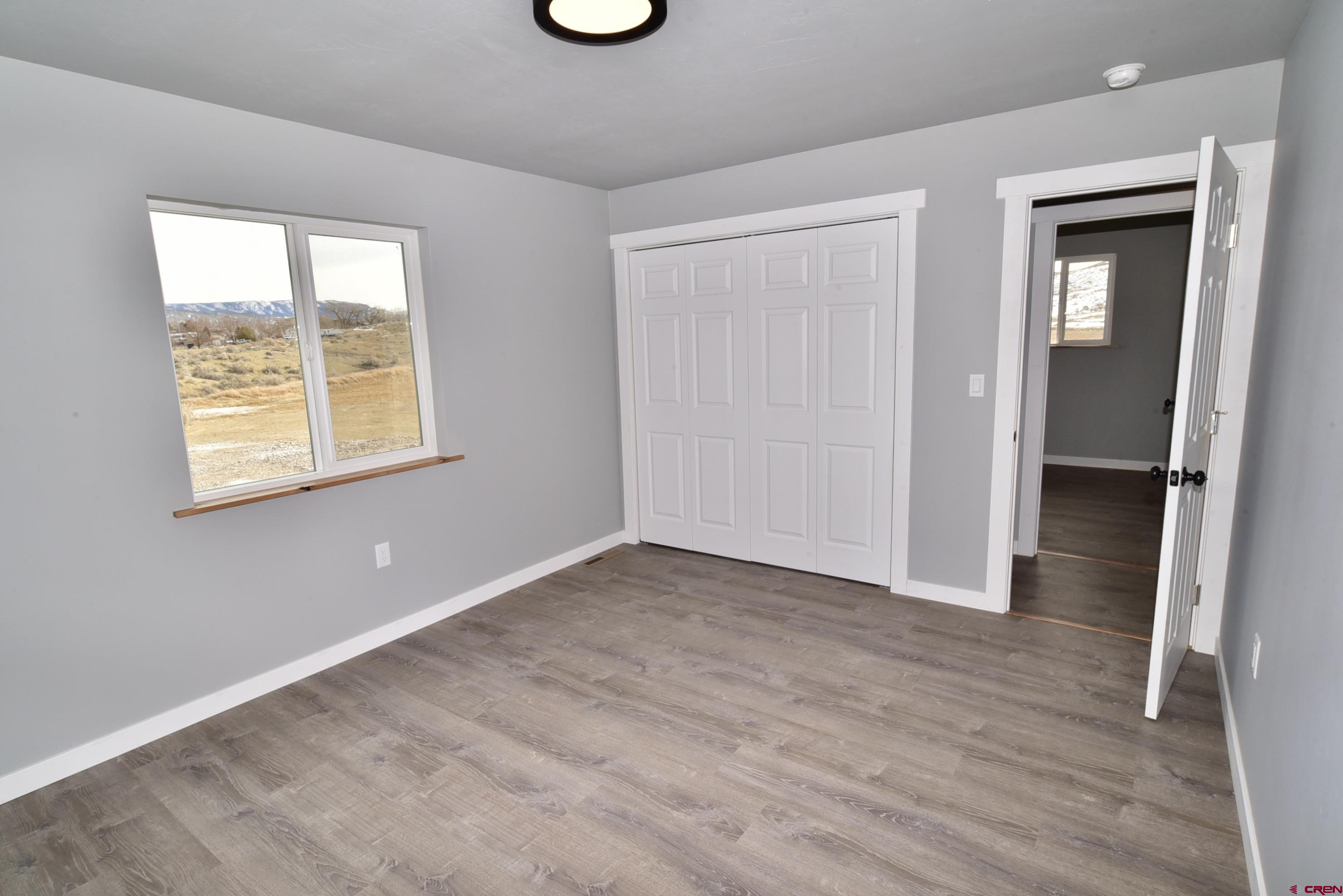 66462 Landfill Road Montrose, CO 81401 - Photo 24 of 30 a view of an empty room with wooden floor and a window