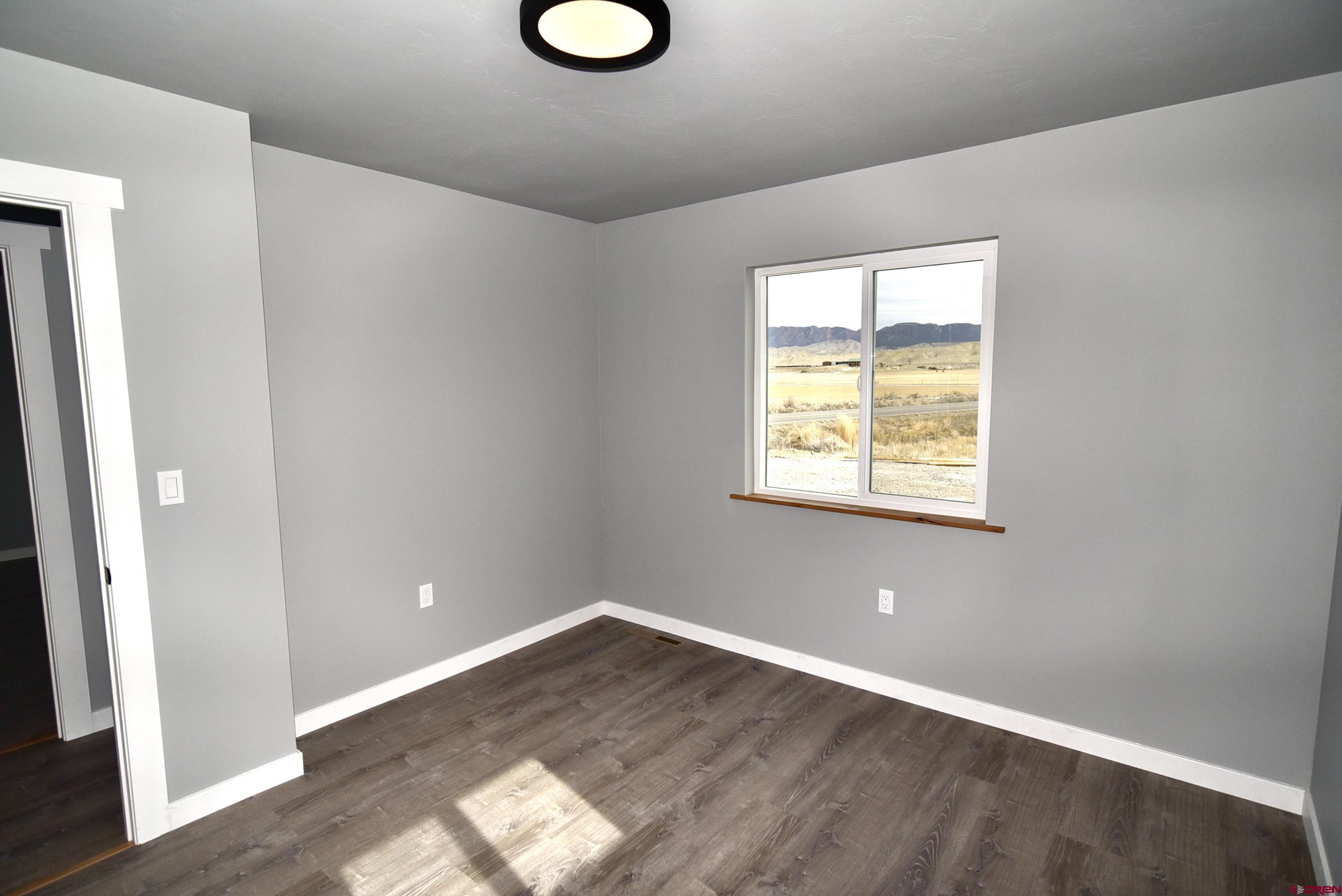 66462 Landfill Road Montrose, CO 81401 - Photo 26 of 30 an empty room with wooden floor and windows