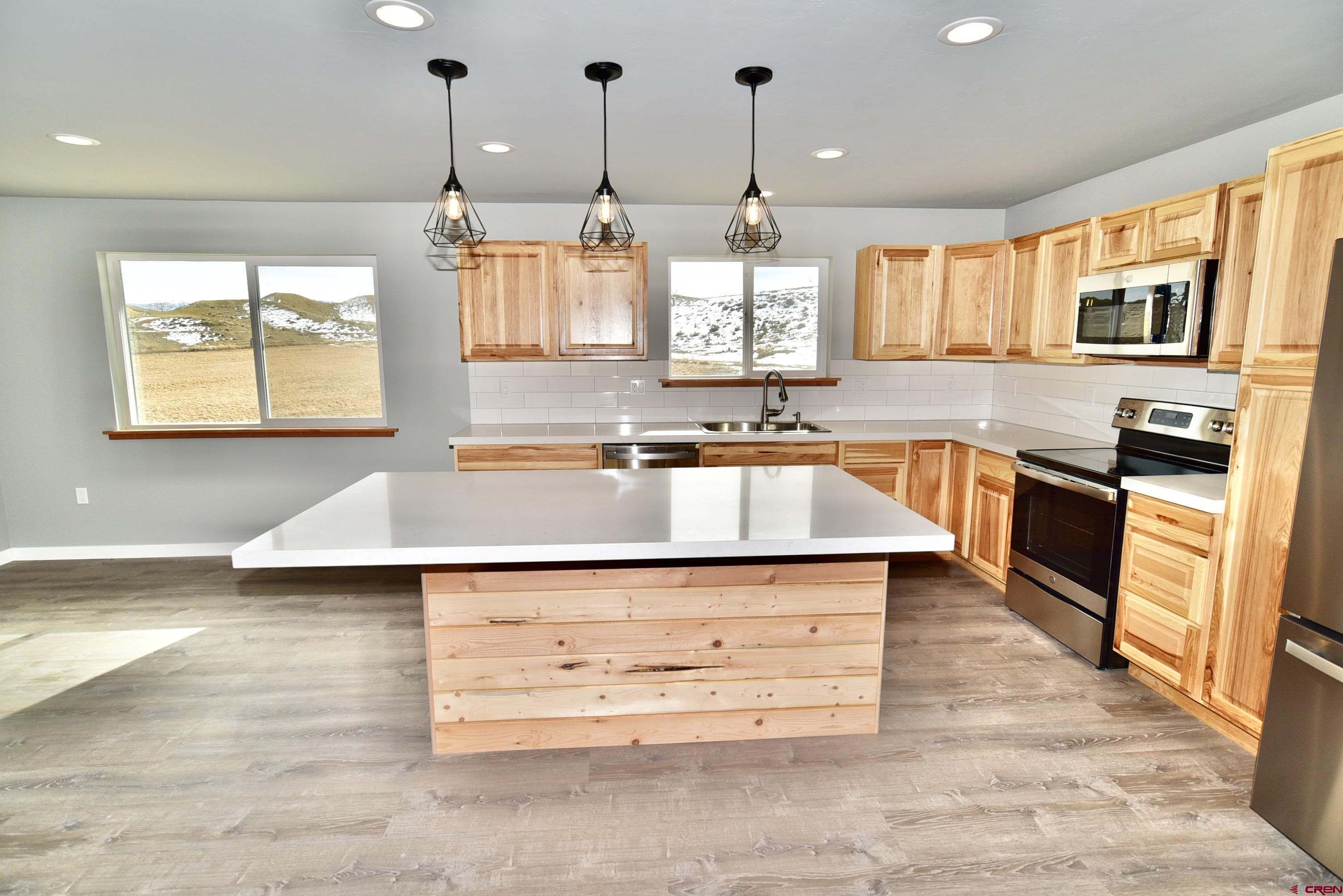 66462 Landfill Road Montrose, CO 81401 - Photo 7 of 30 a kitchen with stainless steel appliances granite countertop a sink a stove and a wooden floors