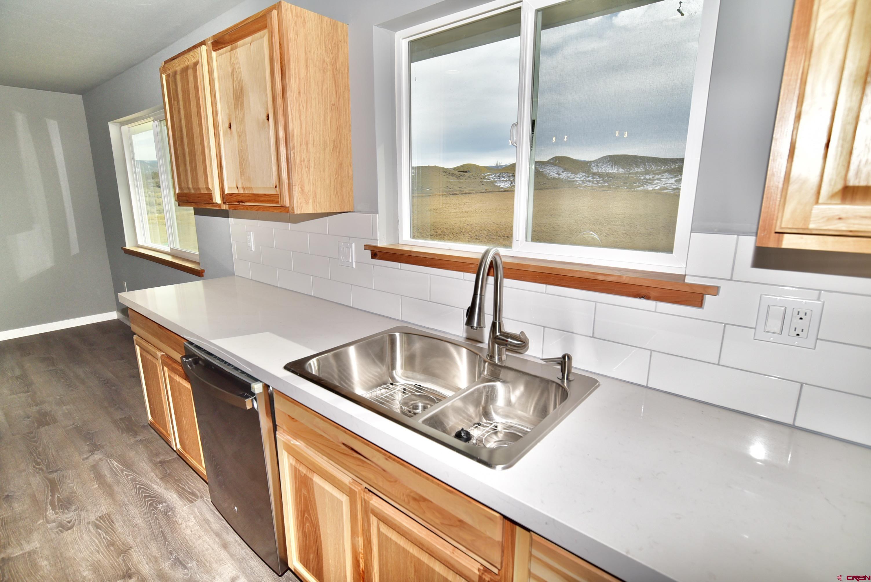 66462 Landfill Road Montrose, CO 81401 - Photo 8 of 30 a kitchen with stainless steel appliances granite countertop a sink and a window