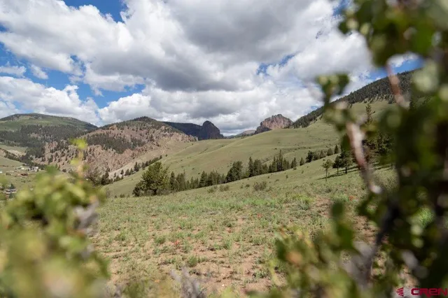 a view of a field with mountains in the background