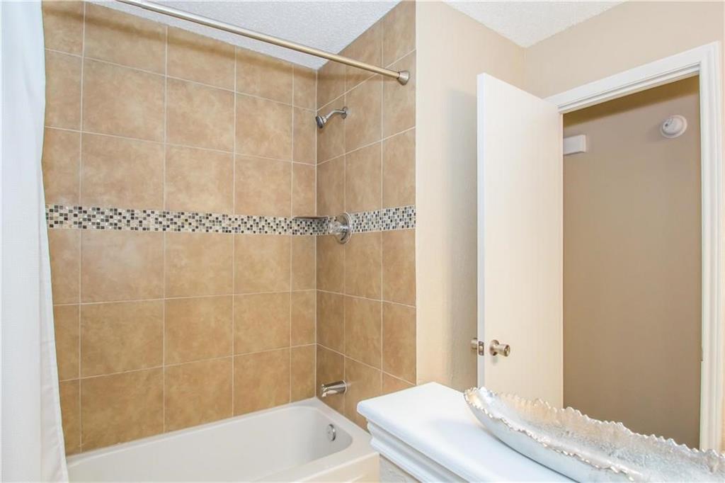 2405 Cranberry Lane Euless, TX 76039 - Photo 12 of 19 Full bath featuring shower / bath combo with shower curtain and a textured ceiling