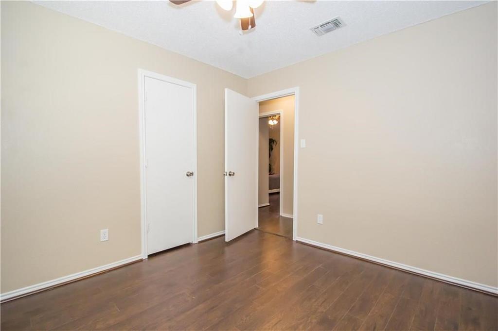2405 Cranberry Lane Euless, TX 76039 - Photo 13 of 19 Unfurnished bedroom featuring dark wood-style floors, a ceiling fan, and a closet