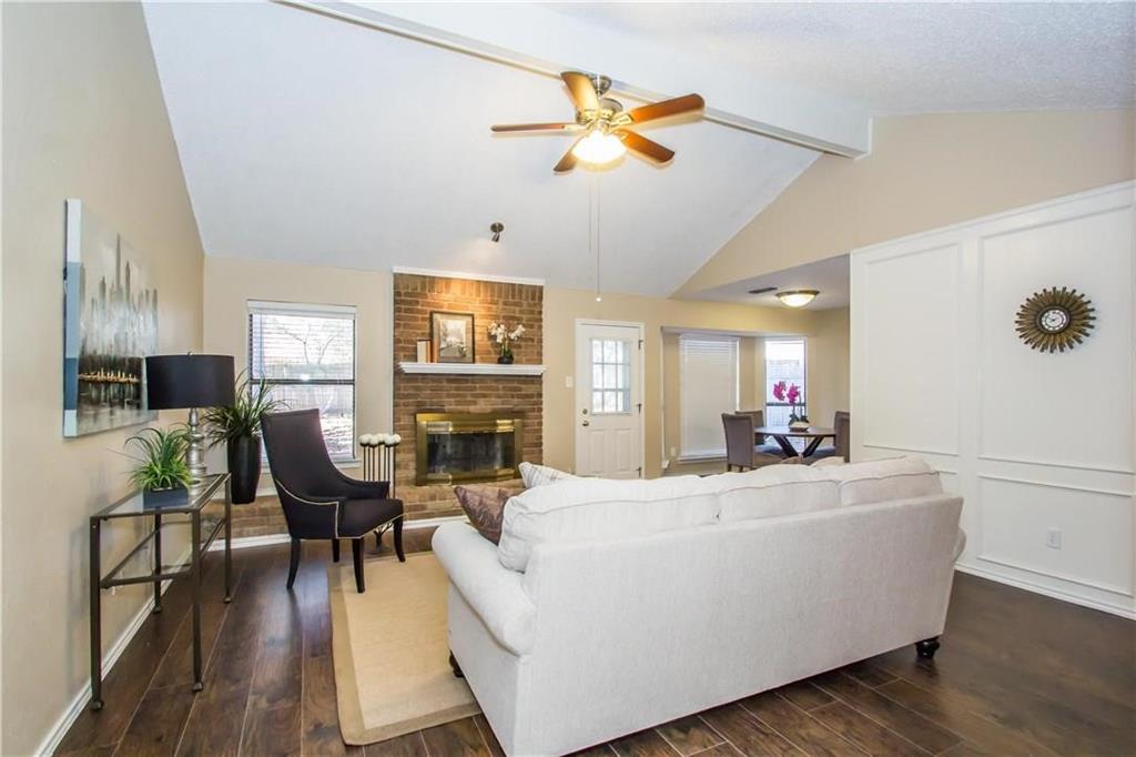 2405 Cranberry Lane Euless, TX 76039 - Photo 4 of 19 Living area featuring dark wood-style flooring, a brick fireplace, and a ceiling fan
