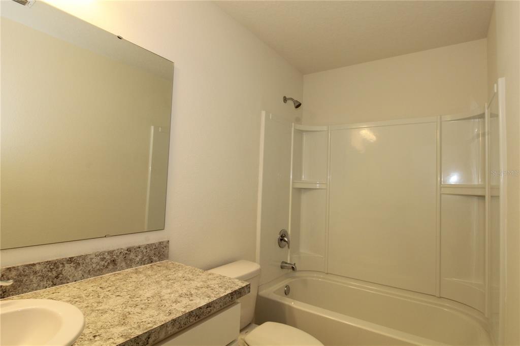 2233 Litchfield Loop DeLand, FL 32720 - Photo 17 of 20 a bathroom with a granite countertop sink and a mirror