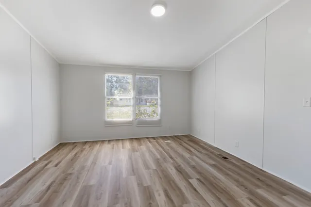 a view of empty room with wooden floor