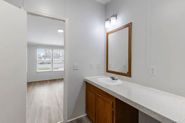 a view of hallway with a window and wooden floor