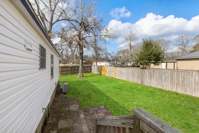a view of backyard with wooden fence