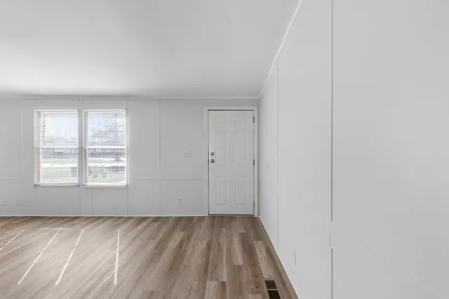 a view of a room with wooden floor and window
