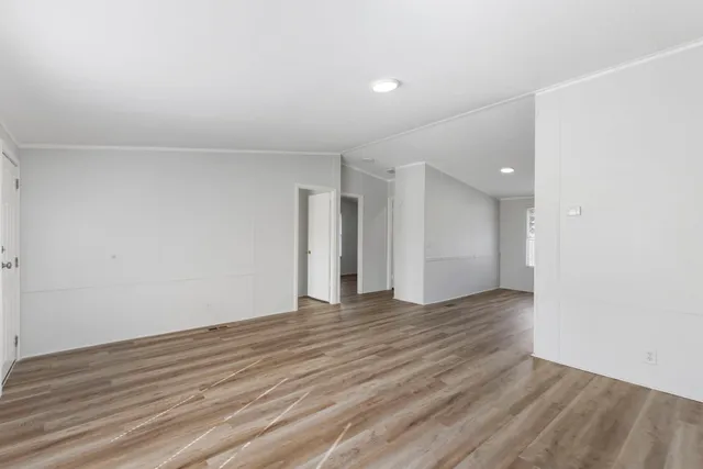 a view of an empty room with wooden floor
