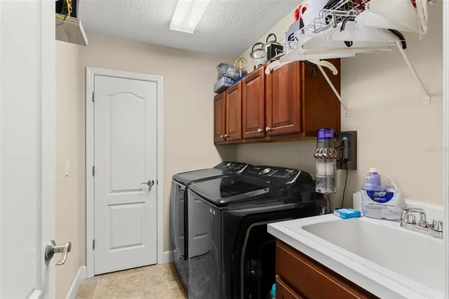 a utility room with sink dryer and washer