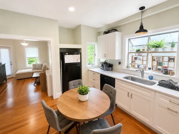 a kitchen with a table chairs stove and wooden floor