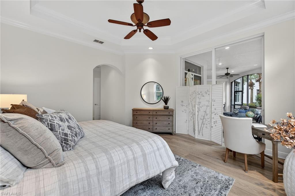 28540 Calabria Court, Unit 101 Naples, FL 34110 - Photo 17 of 41 Bedroom featuring ceiling fan, light wood finished floors, arched walkways, recessed lighting, and crown molding