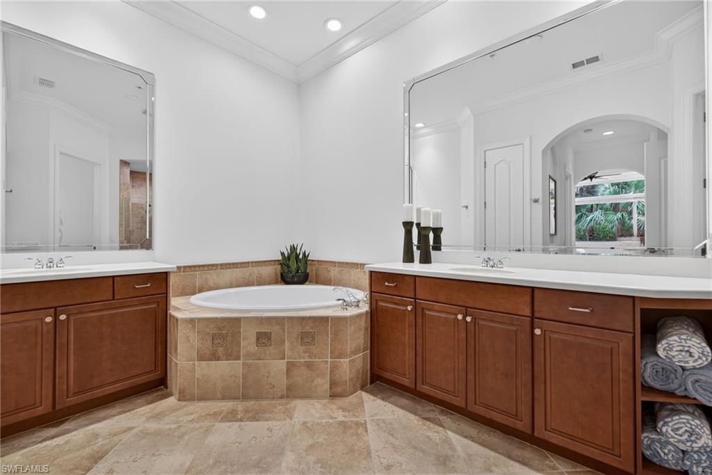 28540 Calabria Court, Unit 101 Naples, FL 34110 - Photo 18 of 41 Full bath with two vanities, crown molding, a garden tub, and recessed lighting