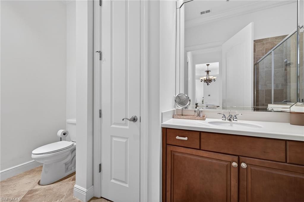 28540 Calabria Court, Unit 101 Naples, FL 34110 - Photo 20 of 41 Bathroom with a stall shower, vanity, a chandelier, and ornamental molding