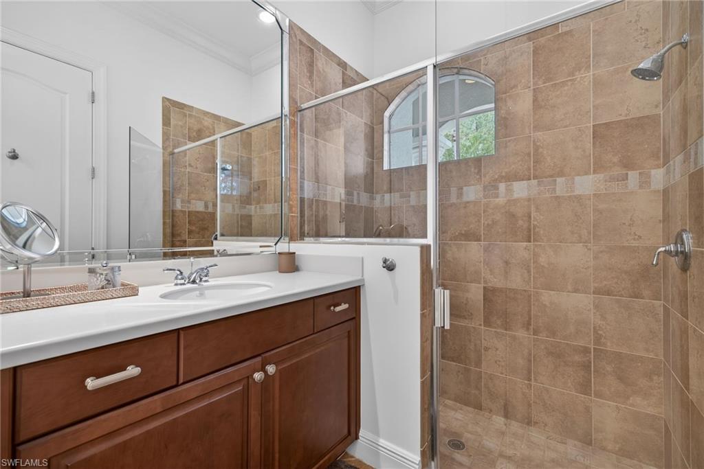 28540 Calabria Court, Unit 101 Naples, FL 34110 - Photo 23 of 41 Full bath with crown molding, vanity, and a shower stall