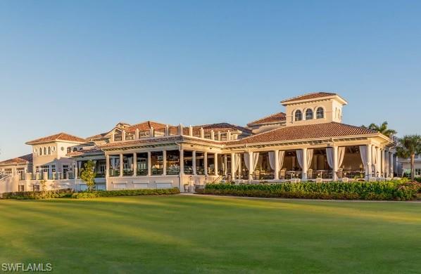 28540 Calabria Court, Unit 101 Naples, FL 34110 - Photo 33 of 41 Rear view of property featuring a yard and a patio area