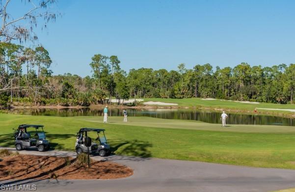 28540 Calabria Court, Unit 101 Naples, FL 34110 - Photo 40 of 41 View of community featuring view of golf course, a yard, view of wooded area, and a water view