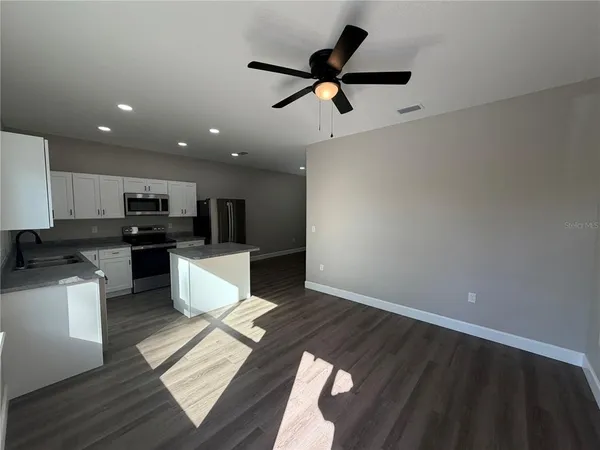 a view of kitchen with microwave and white cabinets