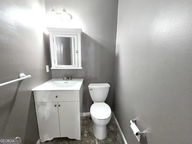 a bathroom with a toilet sink and mirror