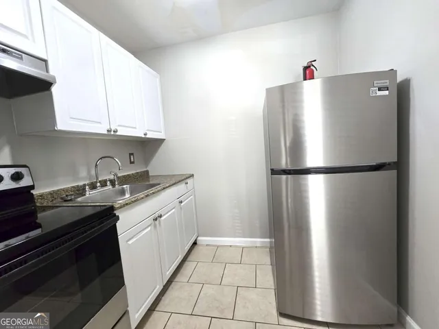 a kitchen with stainless steel appliances granite countertop a refrigerator and a sink