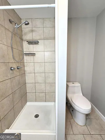 a white toilet sitting next to a bath tub and a shower