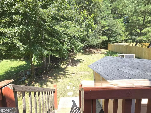 a view of a wooden deck and a backyard