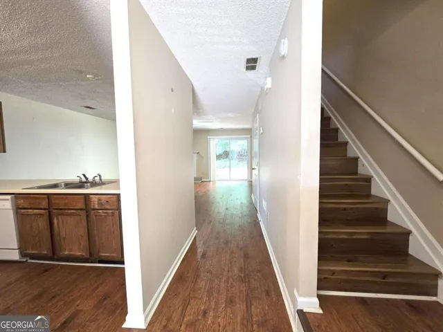 a view of a hallway with wooden floor and staircase